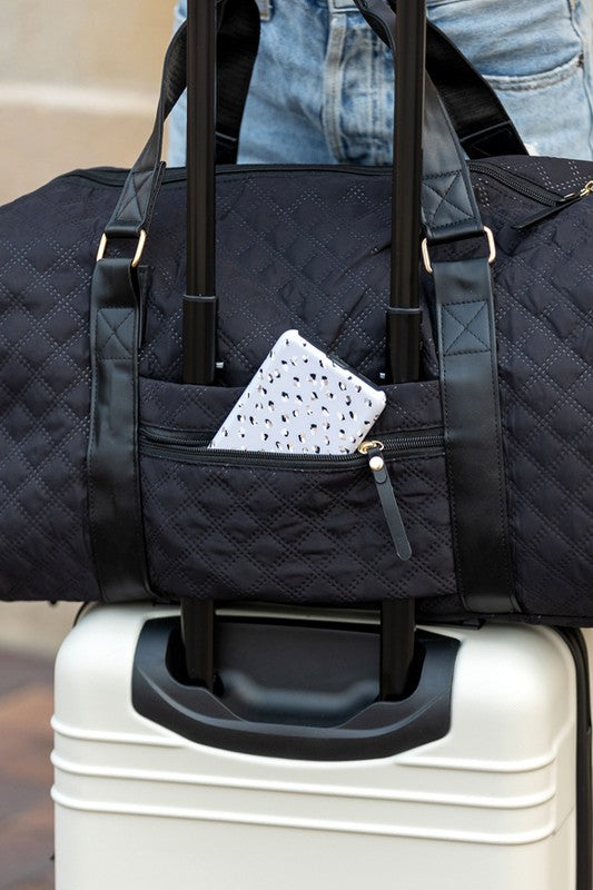 Black quilted duffel bag with a shoulder strap and top handles, ideal for gym or travel.
