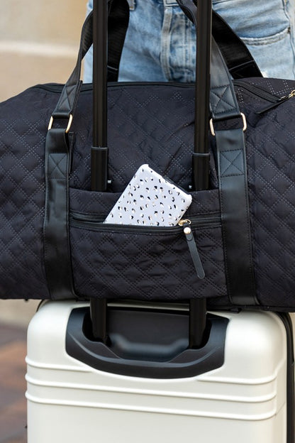 Black quilted duffel bag with a shoulder strap and top handles, ideal for gym or travel.