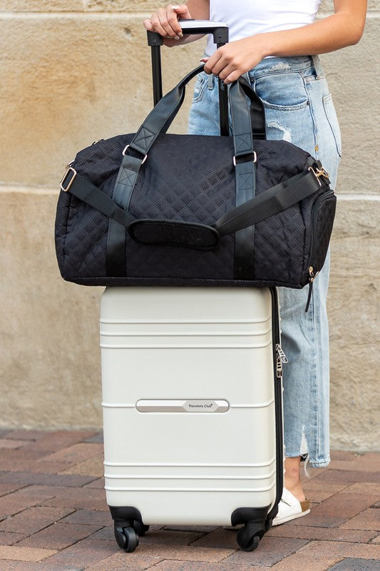 Black quilted duffel bag with a shoulder strap and top handles, ideal for gym or travel.