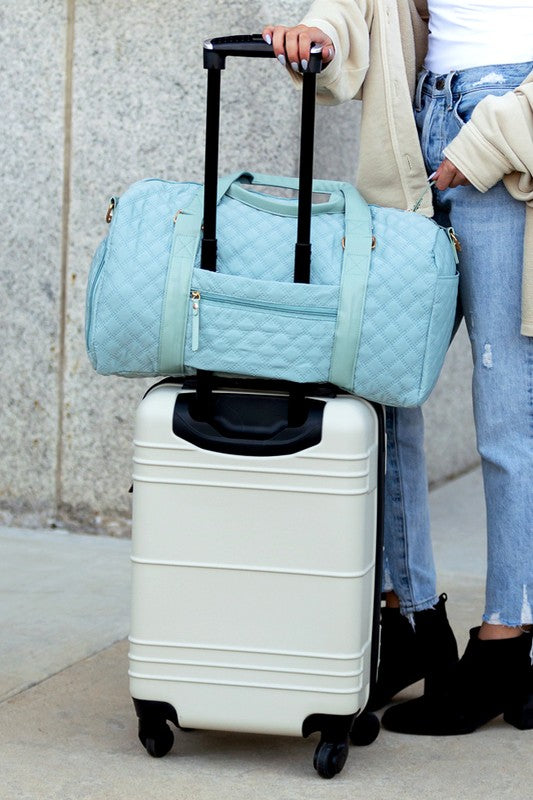 Fashionable light blue quilted weekend bag with a durable design, perfect for short trips.