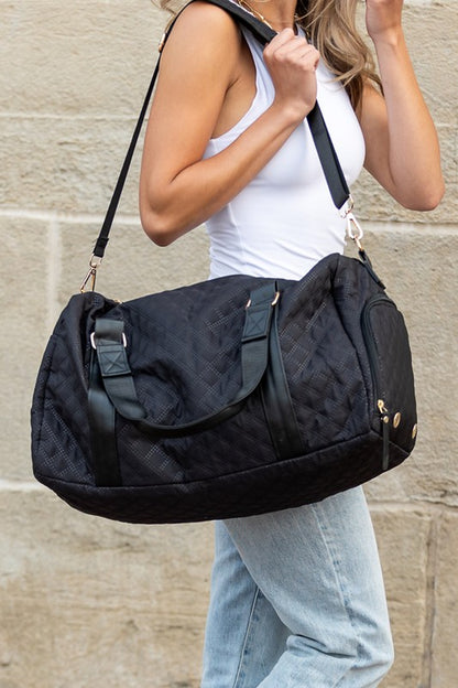 Black quilted duffel bag with a shoulder strap and top handles, ideal for gym or travel.